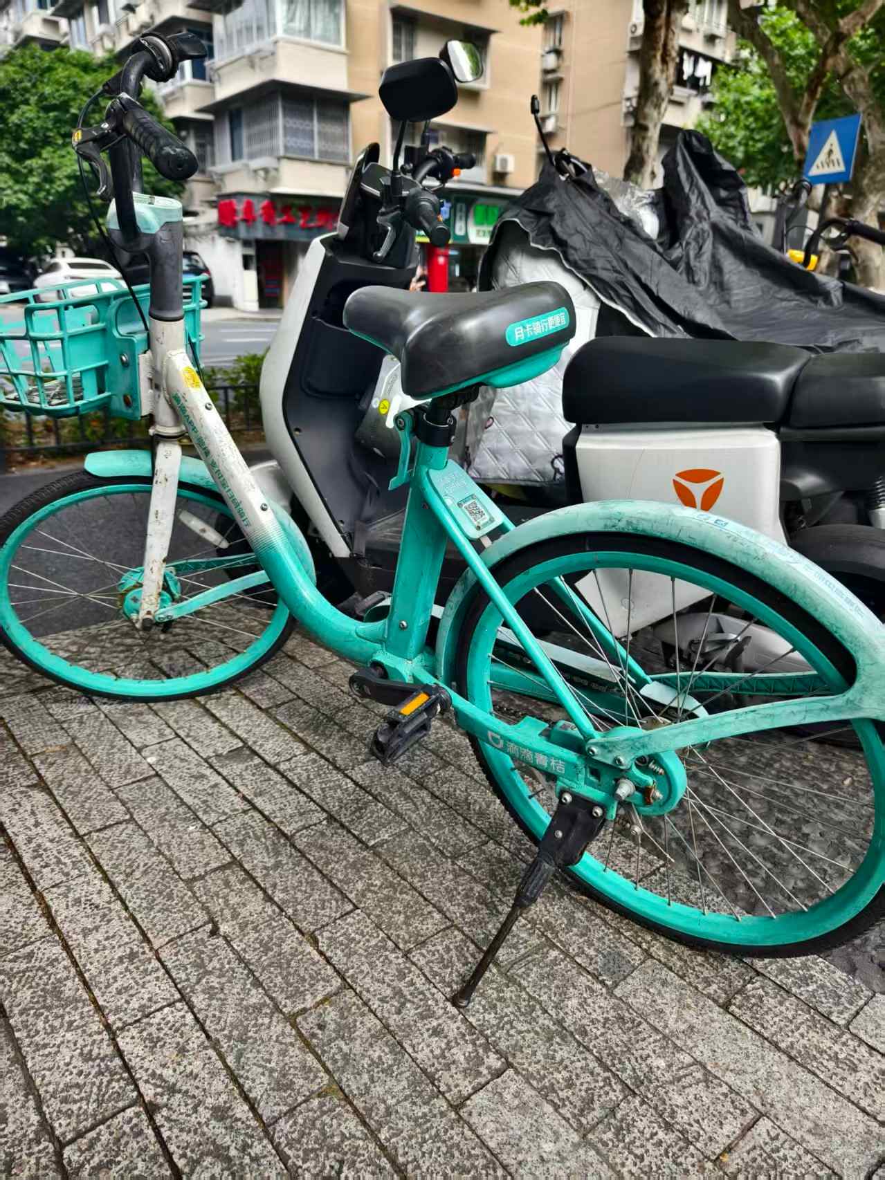 Cyan DiDi Qingju Bike parked on a street in China