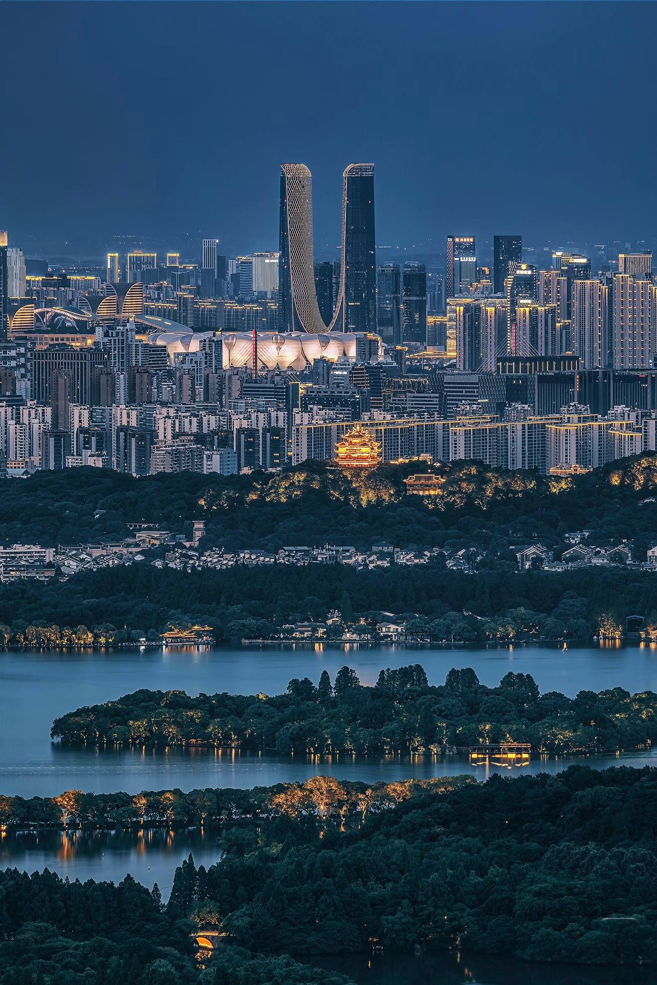 West Lake at dusk, evening lights beginning to glow over the water